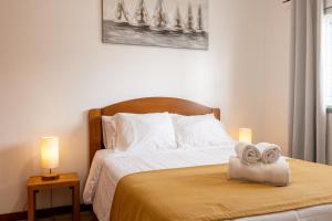 a bedroom with a bed with towels on it at Apartamentos do Triângulo in Velas