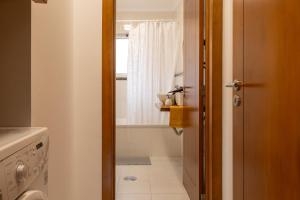 a bathroom with a toilet and a tub and a window at Apartamentos do Triângulo in Velas +41 photos