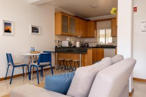 a living room with a couch and a kitchen at Apartamentos do Triângulo in Velas