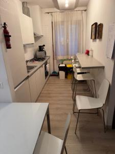 a kitchen with white counters and white tables and chairs at Calle Boldu Venice in Venice