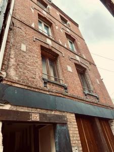 a tall brick building with windows on top of it at Villa Caron - Studios haut de gamme hyper centre in Rouen