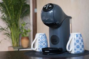 a coffee maker sitting on a table with two cups at Suite Privada Origen 63 Centro Histórico Mérida in Mérida