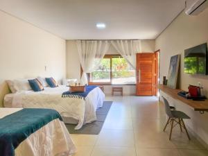a bedroom with two beds and a desk in it at CasaAnacã Ecolounge in Bonito +73 photos