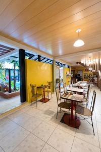 a restaurant with wooden ceilings and tables and chairs at Pousada Villas Boas Arraial do Cabo in Arraial do Cabo