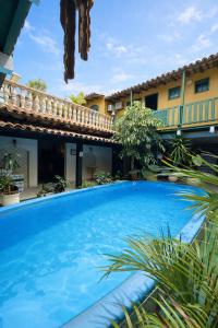 a large blue swimming pool in front of a building at Pousada Villas Boas Arraial do Cabo in Arraial do Cabo