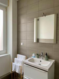 a bathroom with a white sink and a mirror at Au Petit Colombage - Cosy au centre de Mulhouse - Gare proche in Mulhouse +12 photos