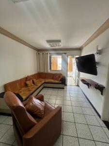 a living room with a couch and a flat screen tv at Apartamento Castelhanos ES in Anchieta