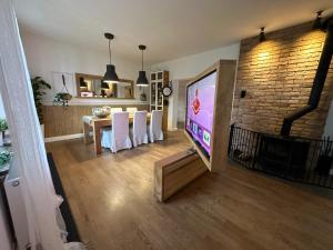 a living room with a tv and a table with white chairs at Dako Apartment, Luxurious, Cosy, Spacious in Rzeszów
