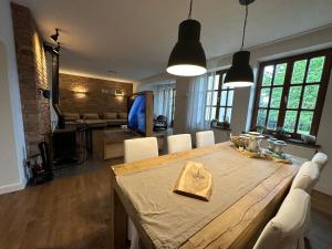 a dining room with a large wooden table with white chairs at Dako Apartment, Luxurious, Cosy, Spacious in Rzeszów +11 photos
