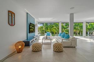 a living room with a white couch and chairs at Villa Ti Karibu in Les Trois-Îlets