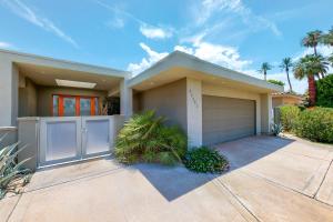 a large house with a garage and palm trees at Desert Retreat in Indian Wells