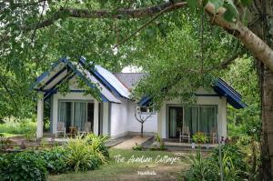 a small white house with a blue roof at The Acadian Cottages in Madampe