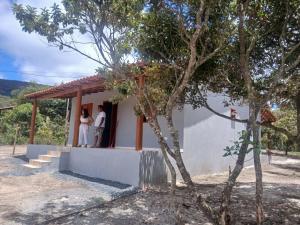 two people standing in the doorway of a house at Casa Cinza Marichi Hospedagem in Vale do Capao