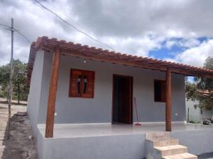 a small white house with a red roof at Casa Cinza Marichi Hospedagem in Vale do Capao