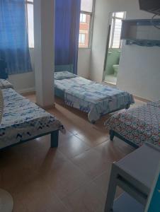 a room with two beds and a bench in it at Hotel Danubio Azul in Yopal +1 photo