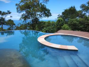 a swimming pool with a wooden coping and blue water at Pousada Samambaia in Paraty