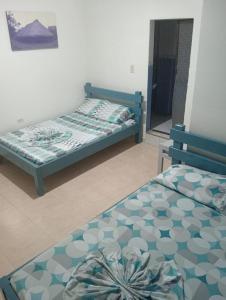 two twin beds in a room with a mirror at Hotel Danubio Azul in Yopal