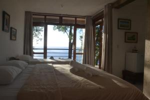 a bedroom with two beds and a large window at Pousada Samambaia in Paraty +41 photos