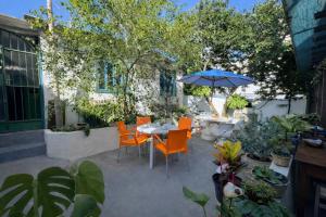 a patio with a table and chairs and an umbrella at Estalagem 11 Suites in Arraial do Cabo