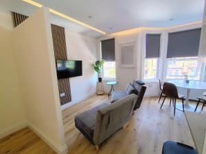 a living room with a table and chairs at Best in Class - London, Harrow in Harrow