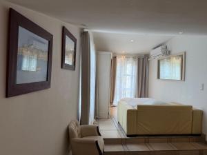 a bedroom with a bed and a couch and a chair at Villa avec piscine à Super Cannes in Vallauris +21 photos