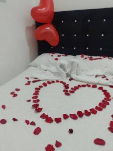 a bed with a heart made out of red roses at Hotel Casa de Oriente in San Bartolo