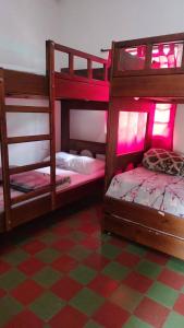 two bunk beds in a room with a checkered floor at Hotel Casa de Oriente in San Bartolo