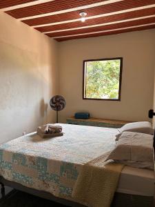 a bedroom with a large bed with a window at Pousada Beira Rio Cipó in Serra do Cipo +127 photos
