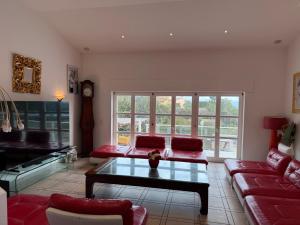 a living room with a red couch and a table at Villa avec piscine à Super Cannes in Vallauris