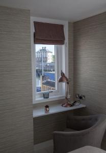 a bedroom with a window with a desk and a lamp at Albero Apartment in Eyemouth +7 photos