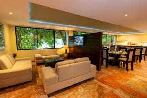 a living room with couches and a dining room at Barceló Ixtapa - All Inclusive in Ixtapa
