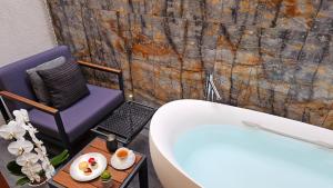 a bathroom with a tub and a chair and a table at Miya Townhouse by Reflections in Kyoto +35 photos