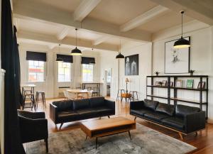 a living room with black leather furniture and a table at Urban Lounge Sleepery Carterton in Carterton