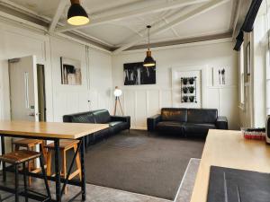a living room with a couch and a table at Urban Lounge Sleepery Carterton in Carterton