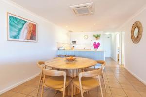 a kitchen and dining room with a wooden table and chairs at Blue Waters - Beachfront and River View - Sleeps 6 -Central Kalbarri in Kalbarri +6 photos