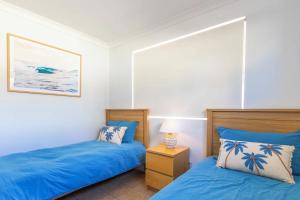 two beds in a bedroom with blue sheets at Blue Waters - Beachfront and River View - Sleeps 6 -Central Kalbarri in Kalbarri