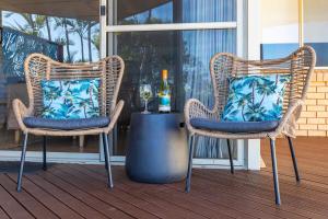 two wicker chairs with blue pillows on a porch at Blue Waters - Beachfront and River View - Sleeps 6 -Central Kalbarri in Kalbarri