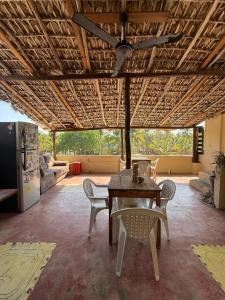 a table and chairs in a living room with a ceiling at TerraZica hostal in Brisas de Zicatela