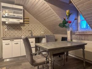 a kitchen with a table and chairs and a vase with flowers at Ferienwohnung Sonnentälchen in Konz