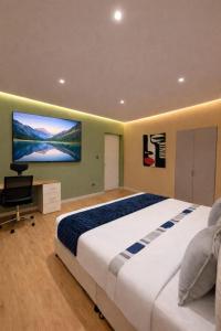 a bedroom with a large bed and a tv on the wall at Suite privada en hotel Boutique in Bogotá