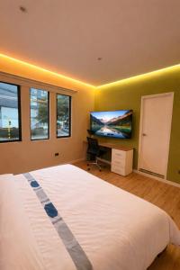 a bedroom with a large bed and a flat screen tv at Suite privada en hotel Boutique in Bogotá