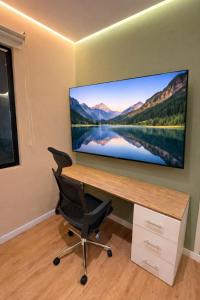 a desk with a large screen tv on a wall at Suite privada en hotel Boutique in Bogotá