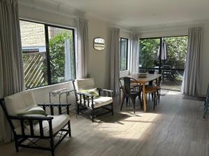 a living room with a table and chairs at Stunning Mount beachside location in Mount Maunganui