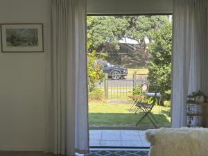 a living room with a door open to a yard at Stunning Mount beachside location in Mount Maunganui