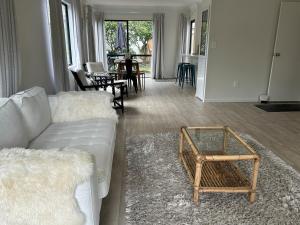 a living room with a couch and a table at Stunning Mount beachside location in Mount Maunganui +21 photos