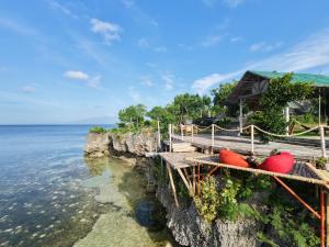 a dock with two red boats on the water at Balay Kumbal in Siquijor