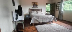 a bedroom with a bed in a room with a window at Pousada Beira Rio Cipó in Serra do Cipo