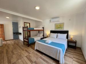 a bedroom with a bed and a bunk bed at Estalagem 11 Suites in Arraial do Cabo