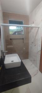 a bathroom with a sink and a shower at chácara vale do sol in Valença +3 photos