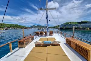 a boat deck with tables and chairs on the water at Private Trip Labuan Bajo 2D1N in Labuan Bajo